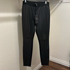 Black fake leather leggings fabric back. Lace up detail